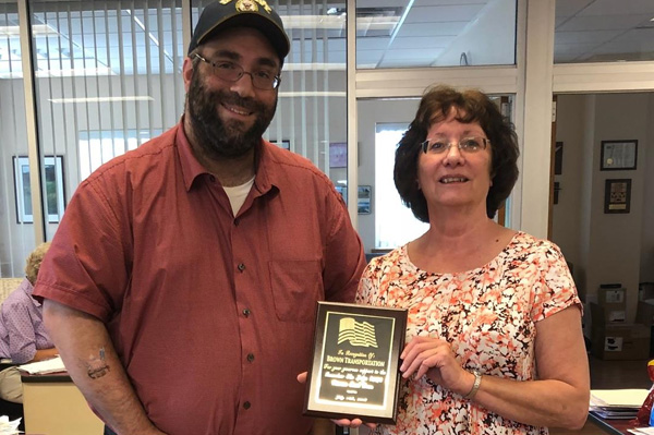 man standing next to a woman holding an office award